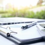 Nowoczesne biuro, na pierwszym planie laptop z wykresem przepływów pieniężnych (cash-flow), obok dokumenty finansowe i kalkulator, czysta estetyka, naturalne światło, styl corporate finance.