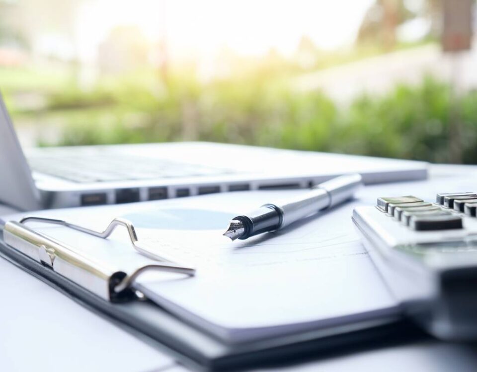 Nowoczesne biuro, na pierwszym planie laptop z wykresem przepływów pieniężnych (cash-flow), obok dokumenty finansowe i kalkulator, czysta estetyka, naturalne światło, styl corporate finance.