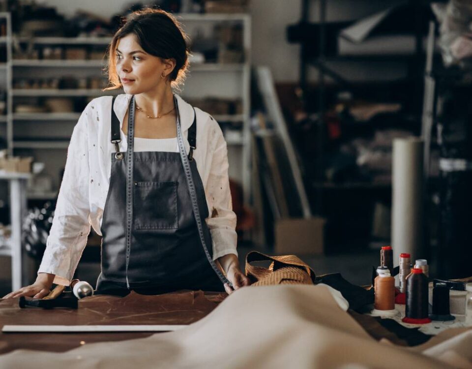 Przedsiębiorczyni w pracowni krawieckiej prowadząca własną działalność gospodarczą