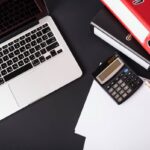 Dokumenty i ekran z analizą wariantów podatkowych w nowoczesnym biurze